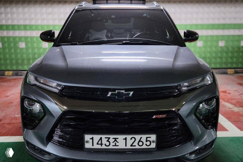 Фронтальный вид серого Chevrolet Trailblazer в подземной парковке, видна решётка, эмблема Chevrolet и южнокорейский номер — фото при осмотре.