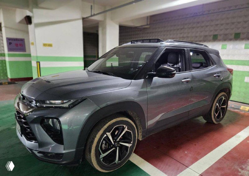 Боковой ракурс Chevrolet Trailblazer: кузов, колёса и общая геометрия автомобиля на парковочном месте, снимок для оценки внешнего состояния.