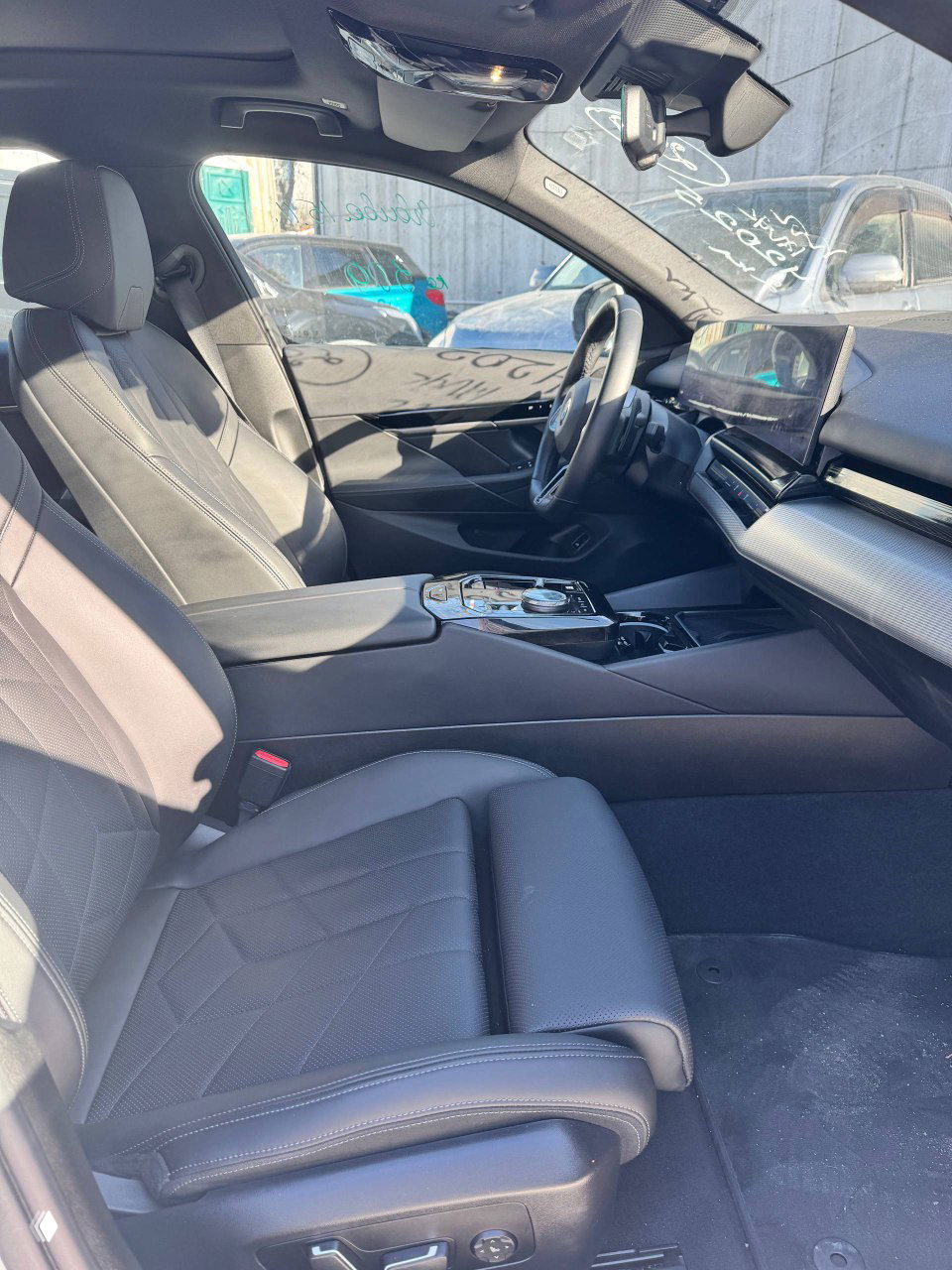 Водительское кресло и передняя часть салона BMW 520i с комфортной обивкой, центральным подлокотником и панорамой торпедо под светом.