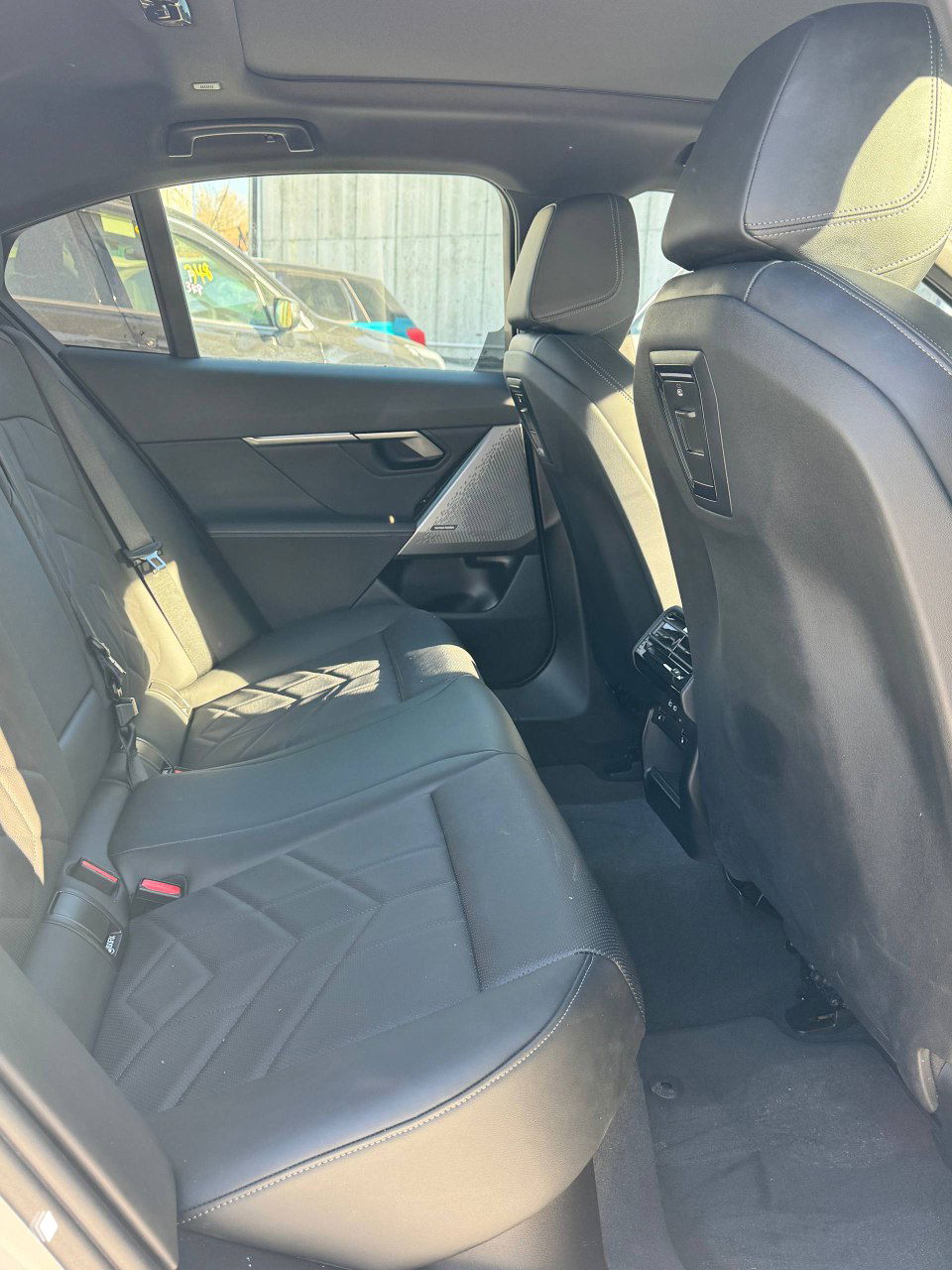 Задний ряд сидений BMW 520i: кожаные сиденья, пространство для пассажиров и вид на заднюю часть передних кресел и воздуховоды.