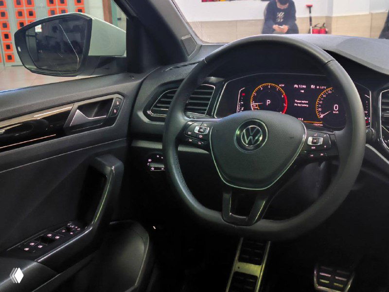 Салон Volkswagen T‑Roc — панель приборов и мультифункциональный руль; фото демонстрирует состояние интерьера и оснащение приборной панели