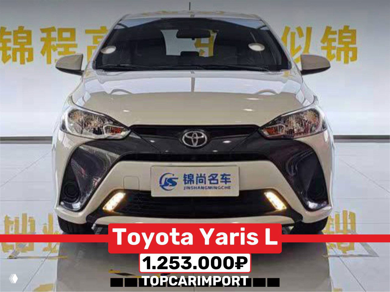 Белая Toyota Yaris L 2021 года, вид спереди; автомобиль в салоне с ценой 1.253.000₽, без следов перекраса на кузове.