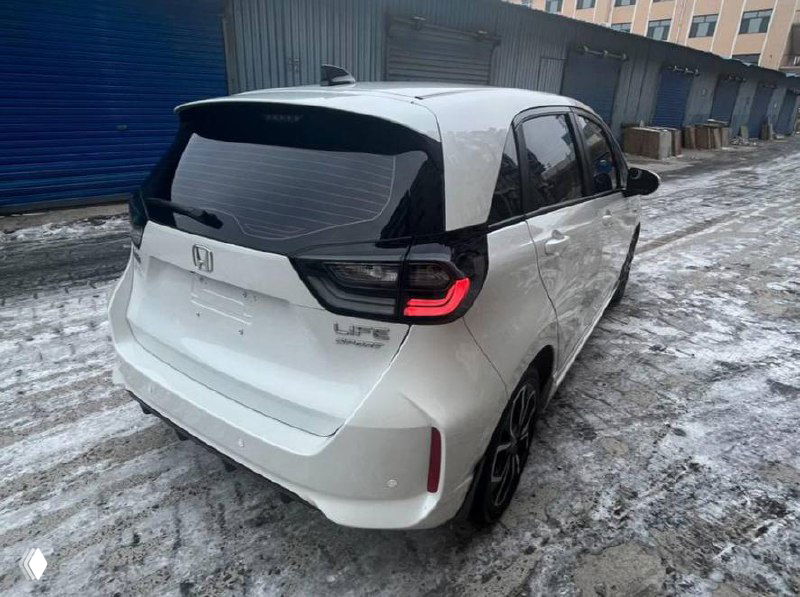 Фото сзади белого Honda Life 2022 на заснеженной площадке, видно фонари, багажник и общий профиль задней части.