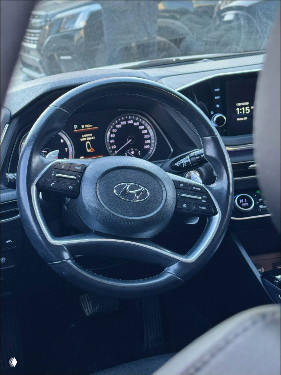 Крупный план рулевого колеса и приборной панели Hyundai Sonata 2022, вид на кнопки управления мультируля и цифровой спидометр в салоне.