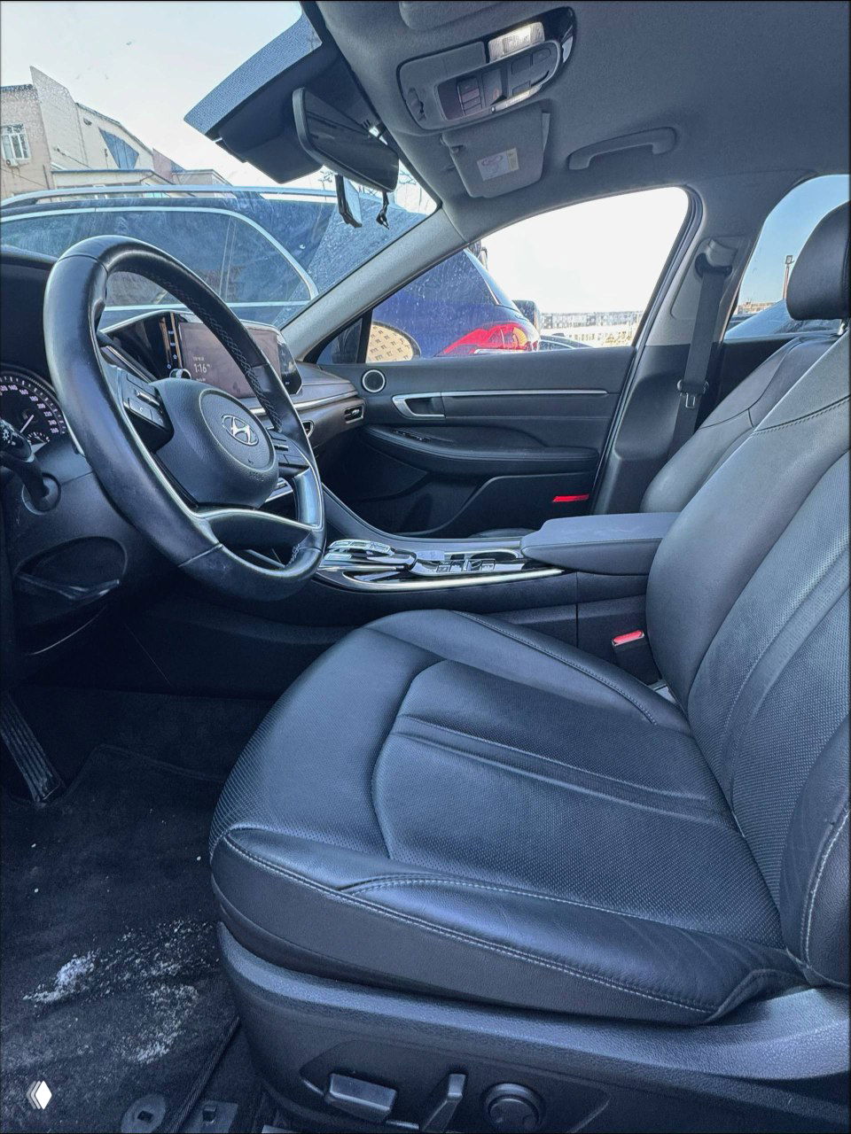 Вид на переднее пассажирское сиденье и водительскую дверь внутри Hyundai Sonata 2022, кожа сидений и консоль в хорошем состоянии.