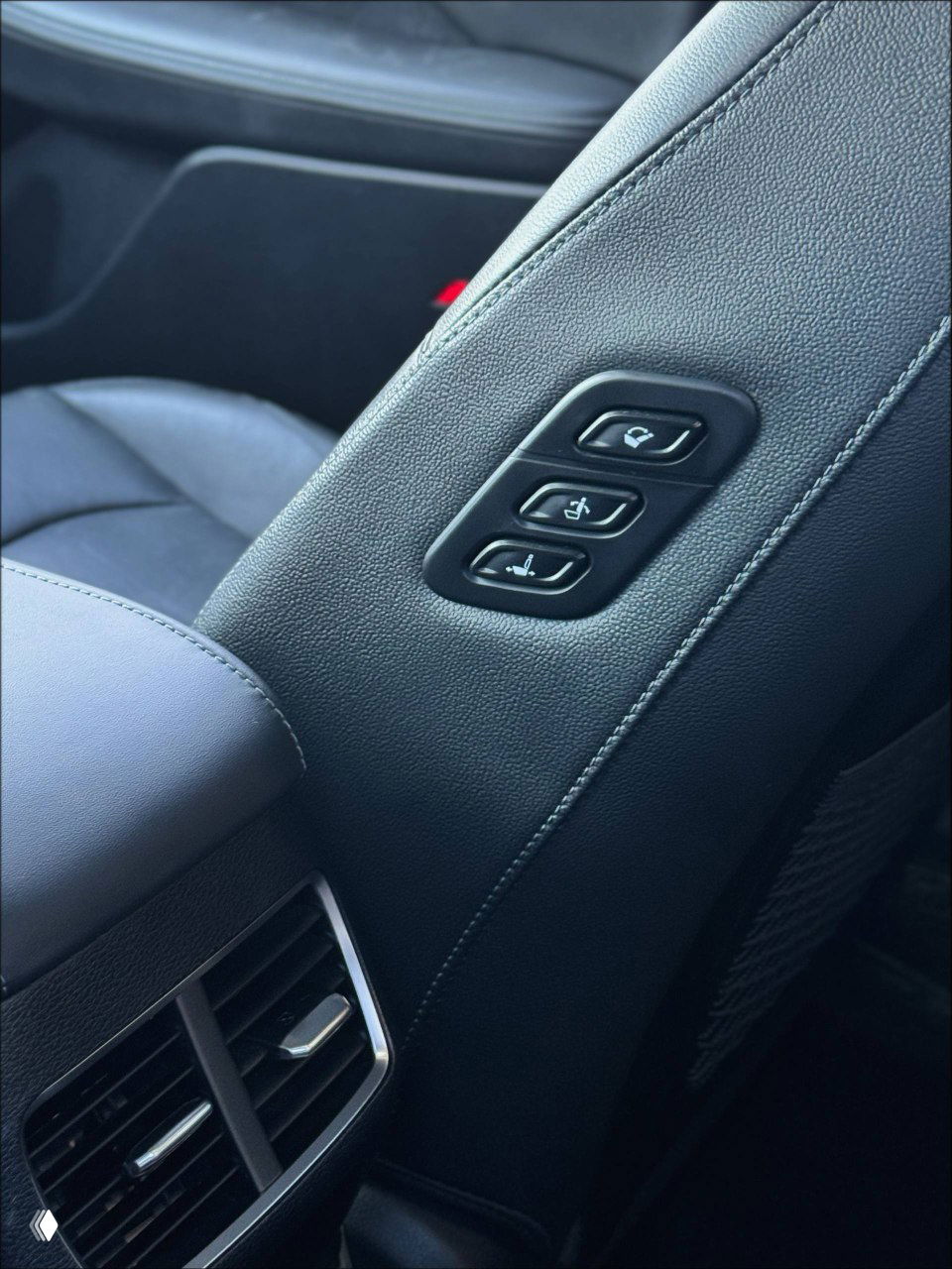 Кнопки регулировки и подлокотник между передними сиденьями Hyundai Sonata 2022, крупный план элементов обшивки и управления комфортом.