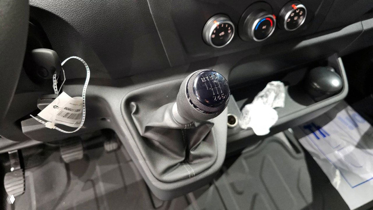 Рычаг механической коробки передач Renault MASTER, ручка КПП и область вокруг переднего пассажирского отсека крупным планом.