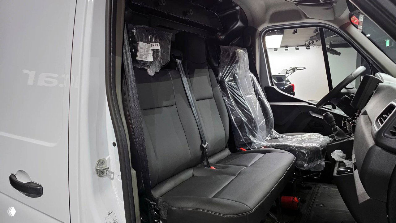 Трёхместный передний диван Renault MASTER, сиденья в защитной плёнке и интерьер кабины с открытой дверью для посадки.
