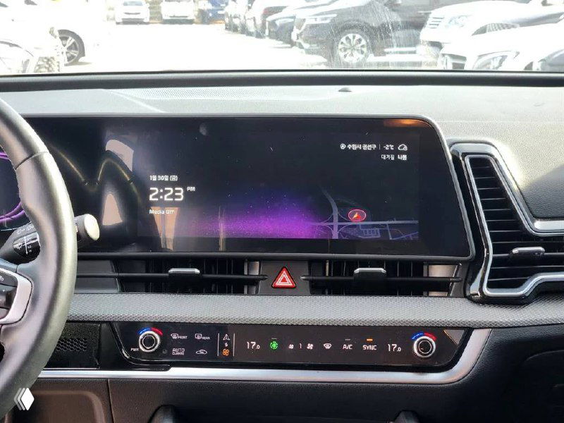 Чёрный мультимедийный экран и климат-контроль KIA Sportage 2024 — крупный план центральной части торпедо с включённым интерфейсом и временем.