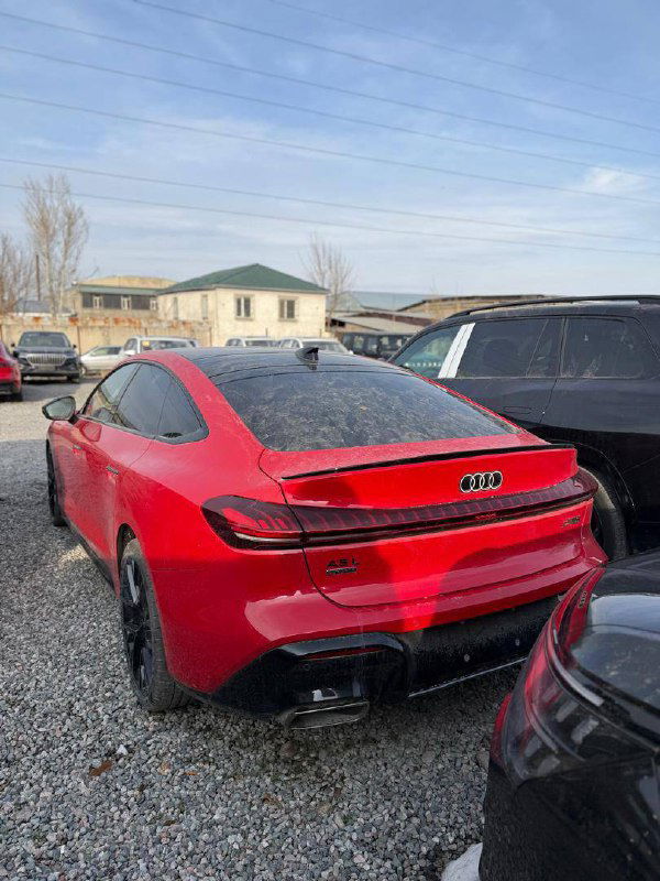 Красный Audi A5L Sportback, вид сзади и боковой части на автостоянке в Киргизии; заметен спойлер и задняя оптика, автомобиль готов к оформлению и отправке.