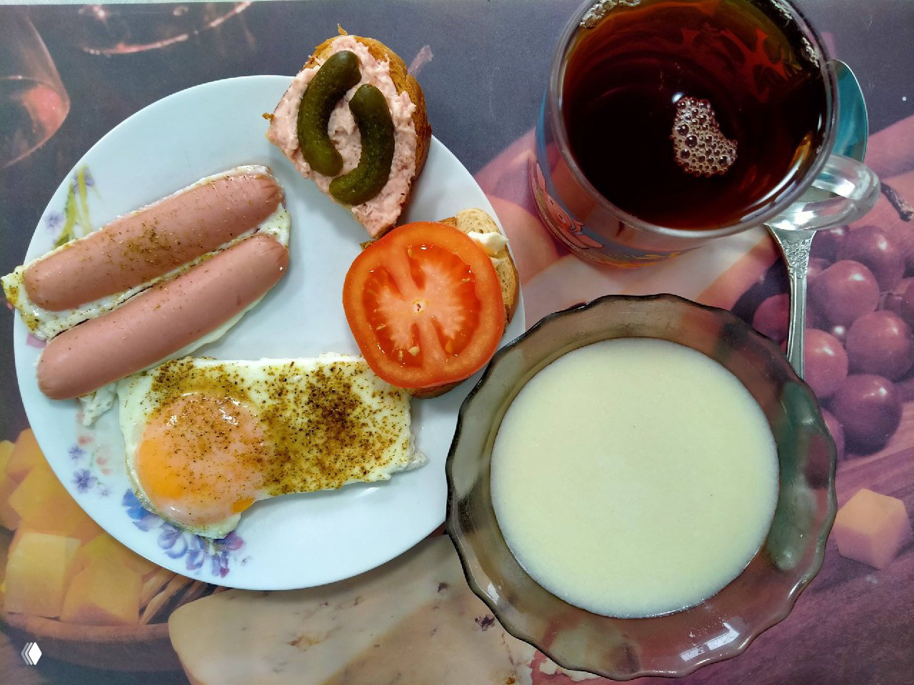 Фотография завтрака на тарелке: яичница, сардельки, бутерброд с помидором и чашка чая — домашнее угощение от мужа автора, как благодарность.