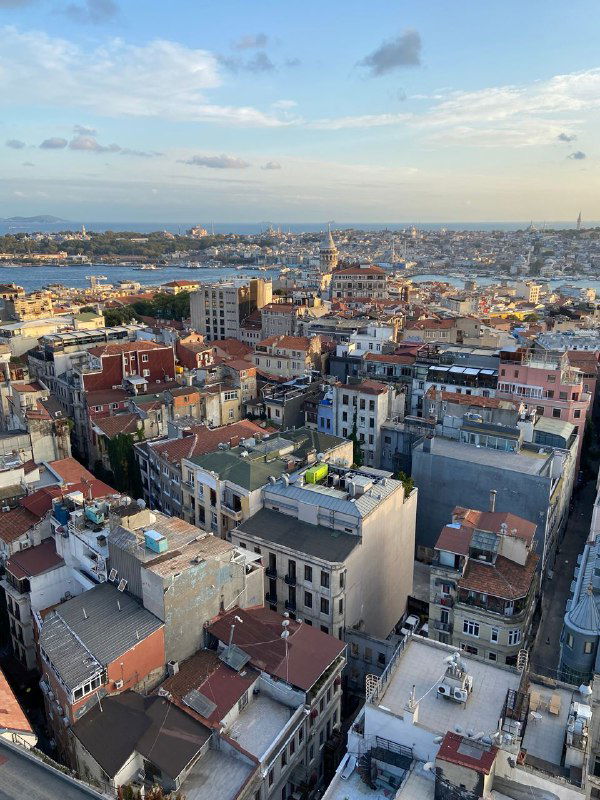 Дневной вид с высоты на плотную застройку Стамбула у побережья, крыши зданий и пролив, снято с высоты 18 этажа.