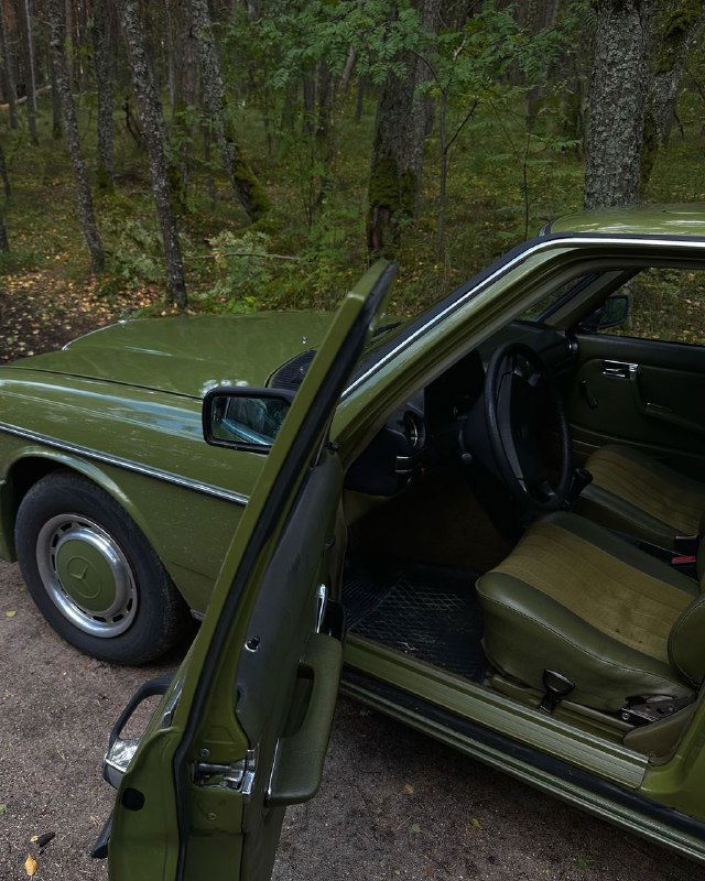 Ретро‑мерседес цвета хакки в лесной или пригородной обстановке: открытая дверь, вид на внутренний салон и детали интерьера автомобиля тура.