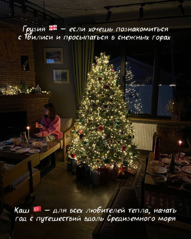 Уютный интерьер с украшенной ёлкой у окна, свечами и видом на заснеженные горы — атмосфера семейного новогоднего путешествия и отдыха.