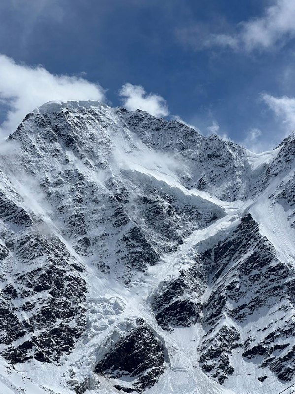 Крутая заснеженная гора с острыми гребнями и снежными карнизами, панорамный вид высокогорья — характерный пейзаж Приэльбрусья.