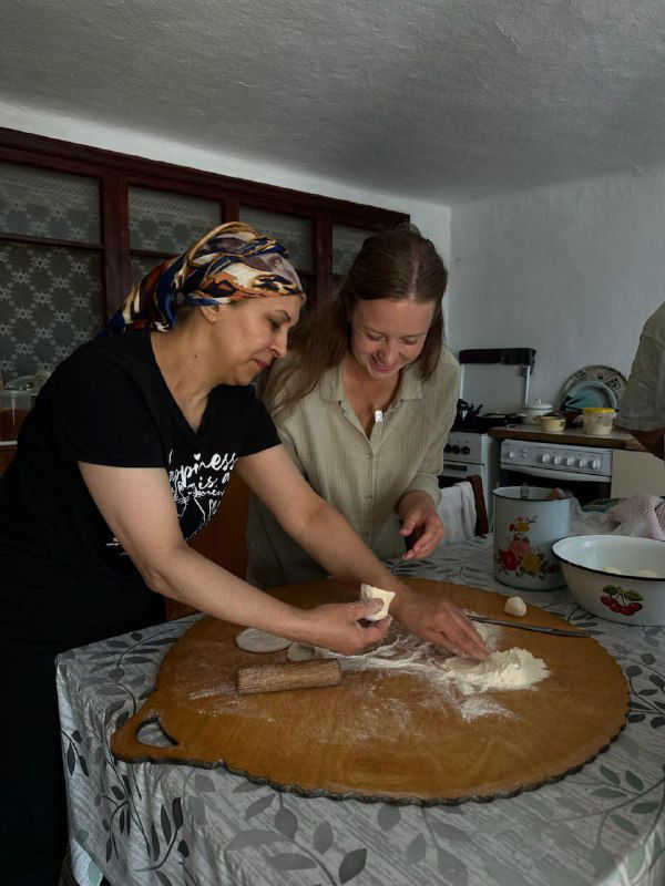 Готовка в домашней кухне: женщины вместе раскатывают тесто и делятся рецептами — часть аутентичного гастрономического опыта.