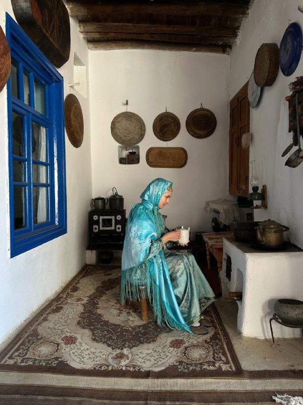 Женщина в традиционной одежде в интерьере дома — спокойный портрет, создающий ощущение уважения к традициям и ритуалам.