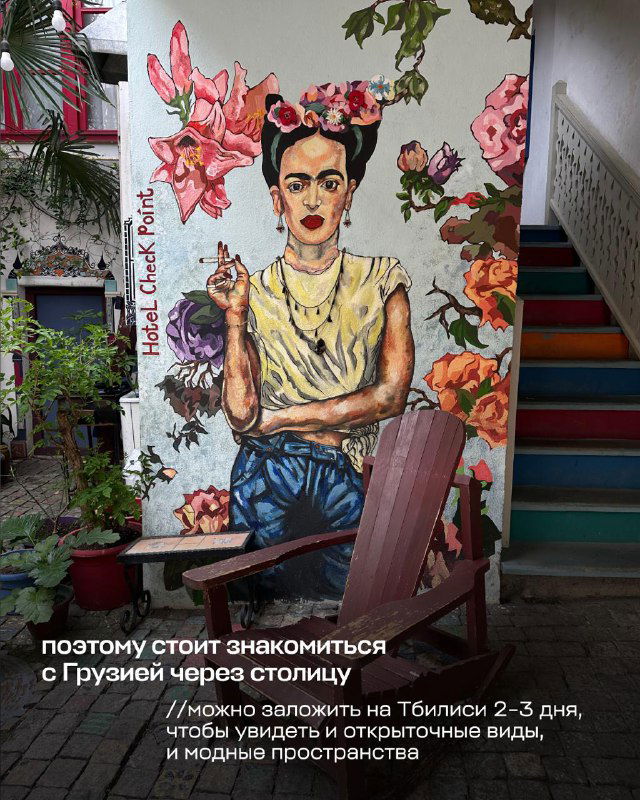 Ярственное настенное граффити с портретом в эклектичном дворике Тбилиси; художественный колорит и уличная эстетика города.