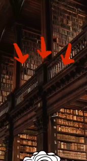 Интерьер большой старинной библиотеки: высокие деревянные стеллажи, множество книг на нескольких уровнях, видны балконы и стрелки.