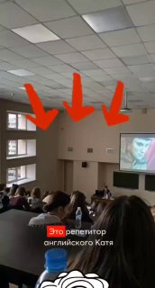 Фото аудитории на занятии: студенты в зале, на экране проекция преподавателя, на стене три красные стрелки и видна подпись.