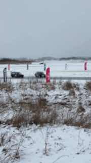 Снеговый полигон для зимнего дрифта в Дмитрове: заснеженная трасса, тренировочные флаги и автомобиль в повороте.