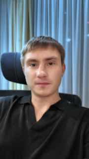 Портрет молодого человека в помещении на фоне штор и кресла; нейтральное лицо, превью к обзору клубов Москвы.