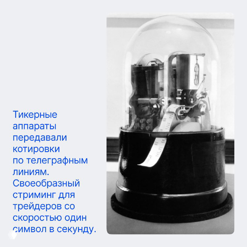 Снимок старого тикерного аппарата под стеклянным колпаком — устройство для передачи котировок по телеграфным линиям.