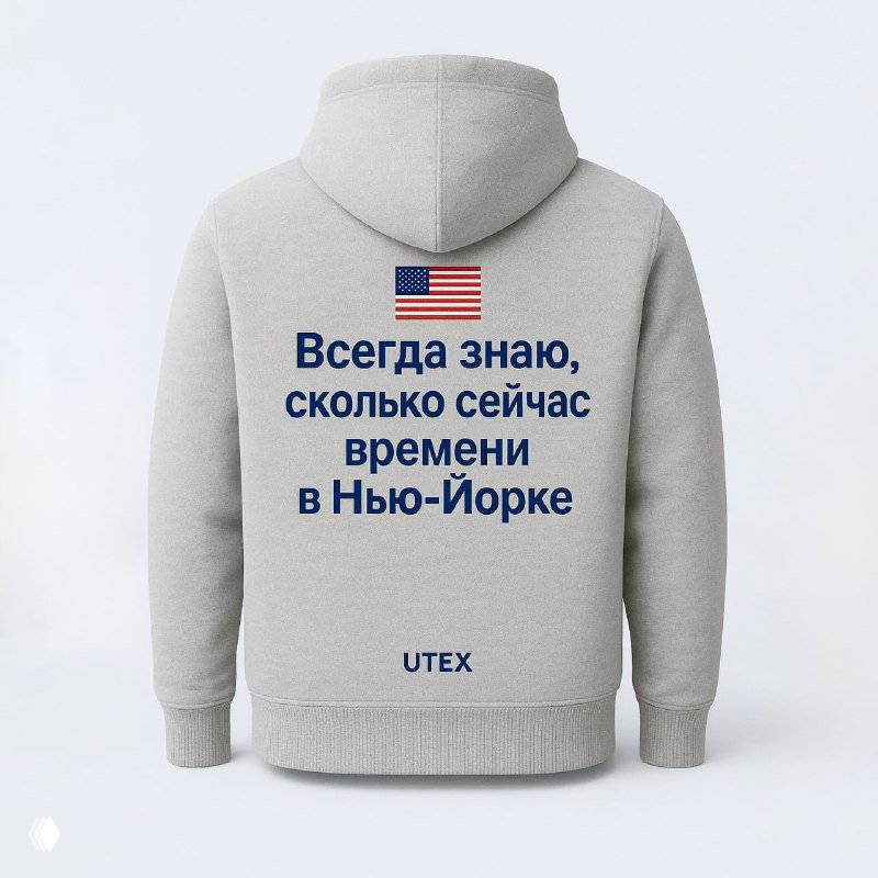 Серое худи UTEX с маленьким флагом США и текстом на спине «Всегда знаю, сколько сейчас времени в Нью-Йорке», показано на модели/манекене — торговый мерч.