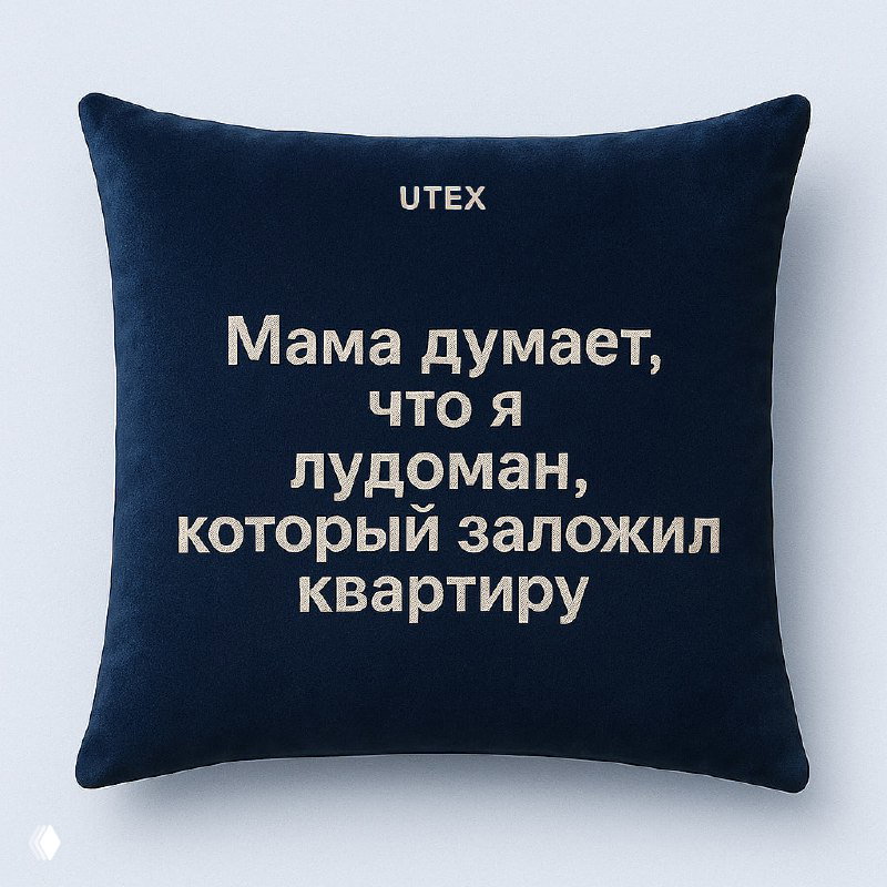 Темно-синяя декоративная подушка UTEX с белой текстовой шуткой про лудоманию и заложенную квартиру, изображение демонстрирует интерьерный мерч в фирменной стилистике.