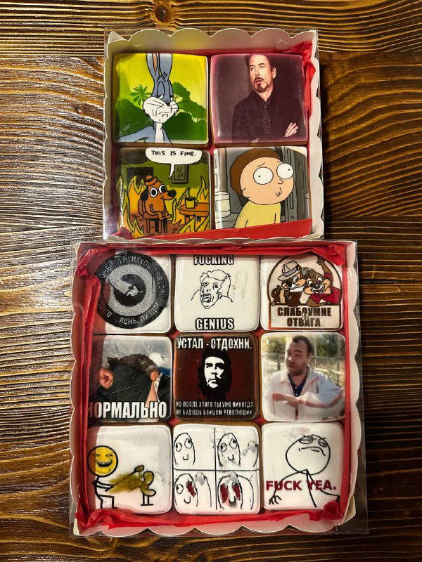 Открытая коробка с печеньками/шоколадками, украшенными избранными мемами и картинками — подарки с юмористическими изображениями.