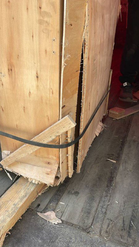 Ещё один деревянный поддон с трещинами и оторванными элементами обвязки: упаковка выглядит полуразобранной после перевозки и таможенных проверок.