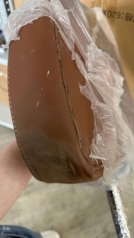 Кусок картонной трубы/упаковки с изломом и помятостью: пример дефекта упаковочного материала и низкого качества упаковывания изделий.