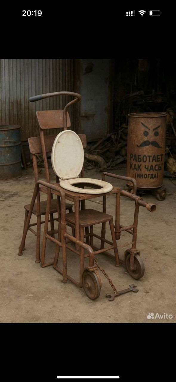 Фото из объявления на Авито: самодельная конструкция с сиденьем унитаза на колёсах, рядом бочка с надписью «РАБОТАЕТ КАК ЧАСЫ (иногда)», грязный двор мастерской.