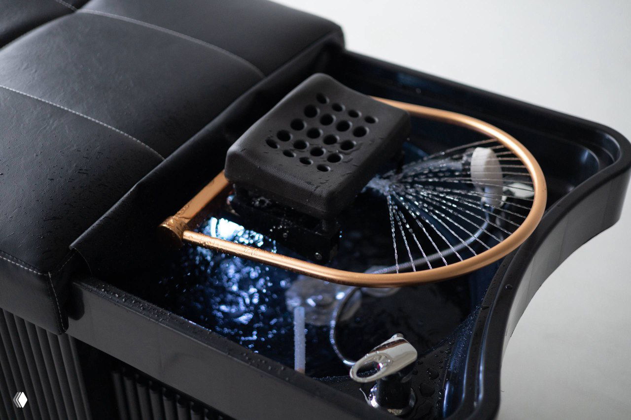 Крупный план раковины и дуги для SpaHead-процедур: часть кушетки с подливом воды и механизмом для процедур и ухода за волосами.