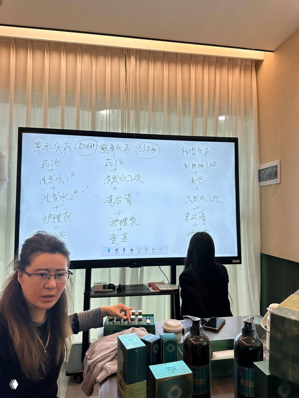 Большая интерактивная панель с рукописными заметками и схемами методик китайской народной медицины во время обучения специалистов салона.