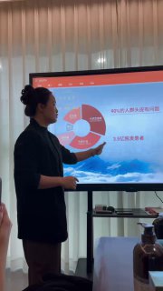 Презентация докладчика у экрана: участники слушают обучение, на столе коробки с продуктами и образцы косметики для практики процедур.