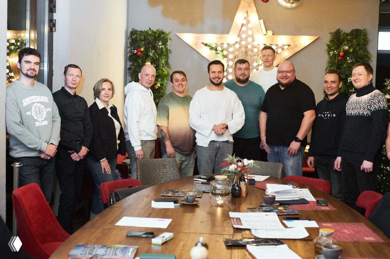 Общая фотография участников тренинга: одиннадцать человек рядом со столом, часть стоит, часть сидит — групповая динамика и командный настрой заметны визуально.