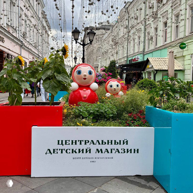 Инсталляция с матрёшками и зелёными насаждениями перед фасадом Центрального детского магазина — праздничная улица и летние павильоны Москвы.