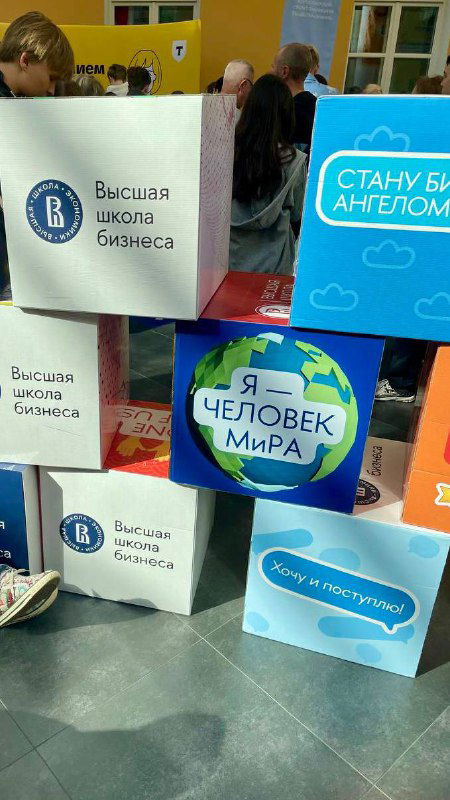 Информационные кубы и стенды с надписями «Высшая школа бизнеса», «Я — человек мира» и другими слоганами на фестивале для школьников, зона промо и коммуникации с абитуриентами.