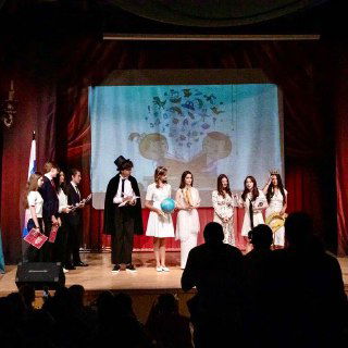 Сцена в школьном театре с выступающими учениками — школьный спектакль, костюмы и реквизит, коллективные творческие активности учащихся.