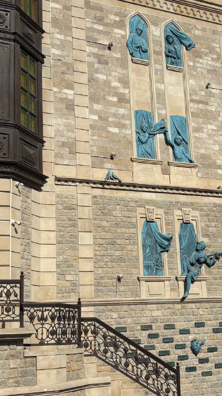 Деталь фасада с барельефами на здании в Баку, украшения и архитектурные элементы вблизи, текстура камня и декоративные элементы