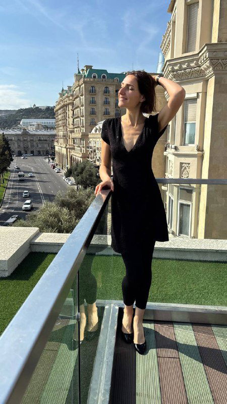 Женский портрет на фоне городской набережной Баку, балкон отеля и вид на городские улицы в солнечном свете, стильная прогулка