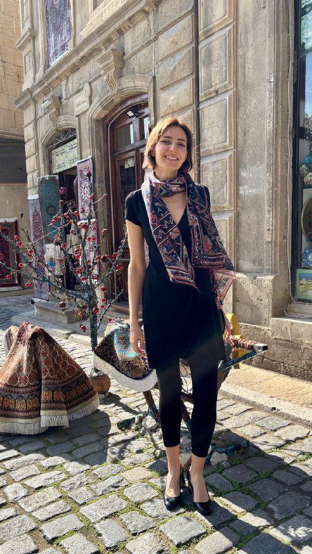 Витрина с коврами и сувенирами в старом районе Баку, уличная торговля и яркие текстильные изделия на фоне архитектуры