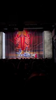 Занавес сцены спектакля с ярким изображением в зрительном зале Театра на Бронной, вид со спины аудитории на сцену