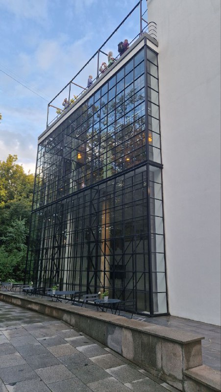 Стеклянный пристенный объём с металлической обвязкой — современный элемент в составе исторического корпуса, вид со двора на фасад с витриной.
