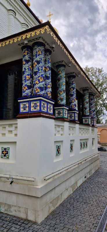 Расписанные керамические колонны и цокольный декор небольшого придела или часовни на территории Спасо‑Преображенской церкви, вид вблизи.
