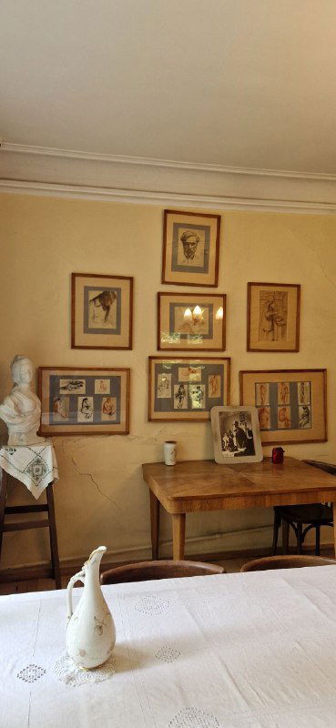 Уютный рабочий уголок дома-музея: стол, стул и развешанные рисунки Леонида Осиповича — всё как при жизни хозяина, аскетично и по-домашнему.