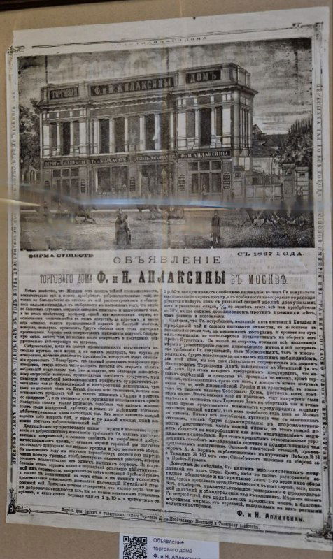 Фотография старинного рекламного объявления в раме: рисунок дома и мелкий текст объявления о торговле чаем Ф. и Н. Аплаксиных, архивный докуент.