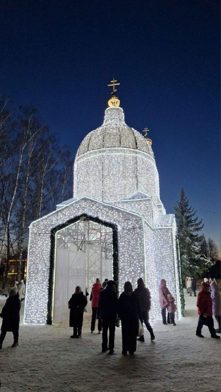 Уменьшенная световая копия разрушенного Спасского собора: купол и арка, люди заходят внутрь светового объёма в зимний вечер.