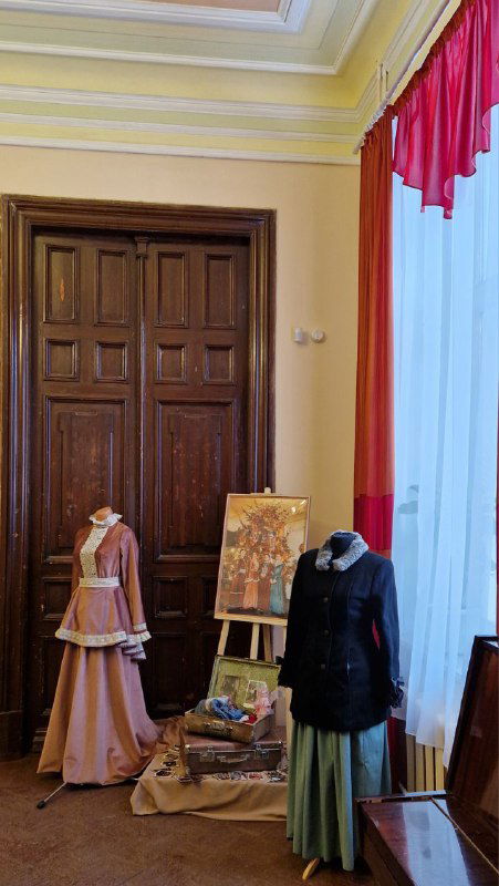Комната-экспозиция с историческими костюмами и живописными полотнами в усадьбе М.А. Павлова; манекены в старинных платьях и музейная витрина.